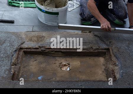 Laying ceramic floor tiles - man hands closeup Stock Photo