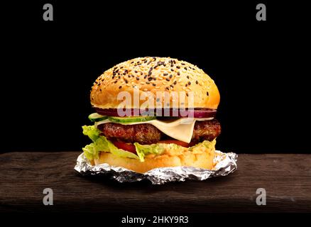 Big single cheeseburger isolated on black background Stock Photo
