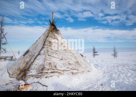 A Nenet chum (tent covered with reindeer skins) in a snow-white tundra landscape. Yamalo-Nenets Autonomous Okrug, Russia Stock Photo