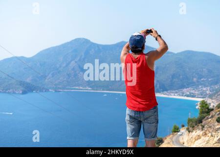 Young athletic man taking photos and video of the sea on vacation with an action cam. Stock Photo