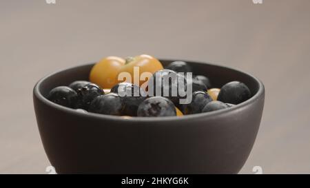blueberries in black bowl with physalis closeup, wide photo Stock Photo