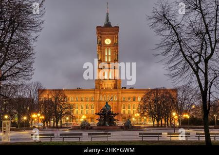 The famous Rotes Rathaus in Berlin at night in winter witrh some barren tree branches Stock Photo