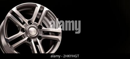 alloy wheel, shiny white-gray on a black background close-up, panoramic layout empty space copy space. Stock Photo