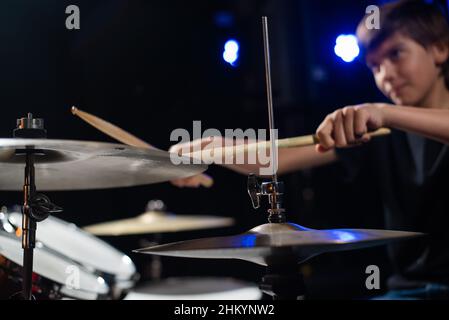 A boy plays drums in a recording studio Stock Photo
