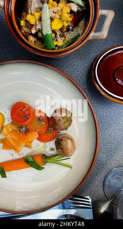 Top down view of organic vegetables such as carrot, tomato and potato on rustic plates Stock Photo