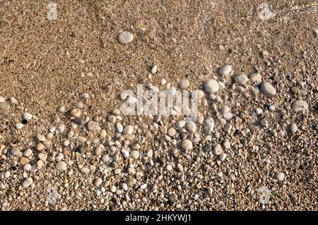 Pebble beach textured background. Close-up of round stones and sand on Mediterranean sea. Paleokastritsa beach on Corfu island, Greece Stock Photo