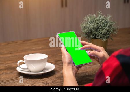 Woman using her smartphone with green screen. Stock Photo