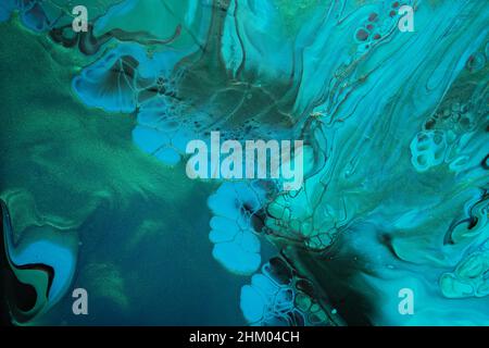 Fluid Art. Green and blue abstract wave swirls on black background. Marble effect background or texture. Stock Photo