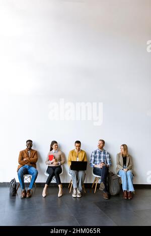 Group of bored young people waiting for the job interview Stock Photo