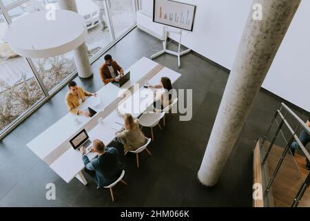 Aerial virew at group of young multiethnic business people working together and preparing new project on a meeting in the office Stock Photo