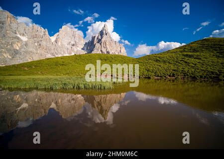 Summits and rock faces of the Pala group, Cimon della Pala, one of the main summits, standing out, reflecting in a lake. Stock Photo