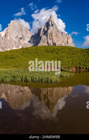 Summits and rock faces of the Pala group, Cimon della Pala, one of the main summits, standing out, reflecting in a lake. Stock Photo
