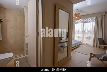 Interior design decor furnishing of luxury show home bedroom showing furniture and double bed with en suite bathroom Stock Photo