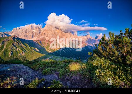 Summits and rock faces of the Pala group, Cimon della Pala, one of the main summits, covered in clouds, at sunset. Stock Photo