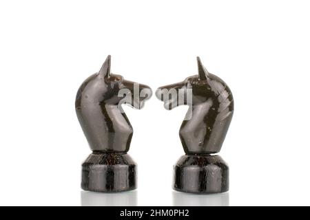 Two old wooden chess pieces in black, macro, isolated on a white background. Stock Photo