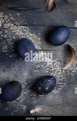 Dyed Easter eggs with marble stone effect painted with natural dye carcade tea from hibiscus flowers on old wooden background with branches of willow Stock Photo