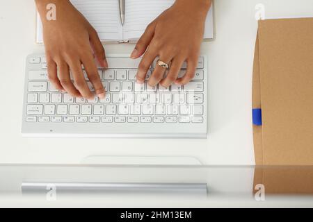Beautiful hands of a dark-skinned woman on a keyboard Stock Photo