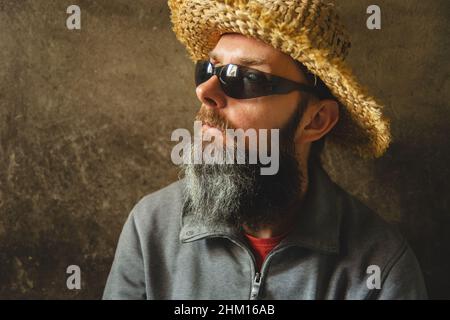A man with a long beard in a straw hat, male portrait Stock Photo