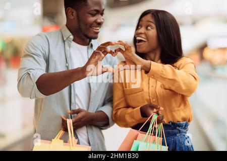 Portrait of black couple making heart shape with hands Stock Photo