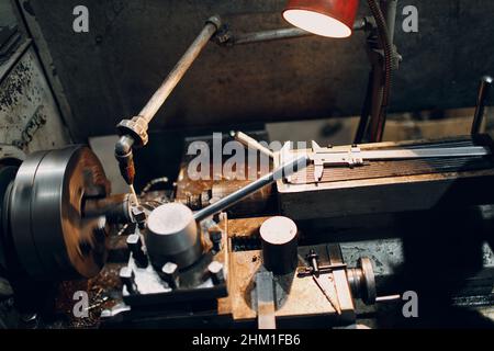 Turner worker working on old lathe machine at factory Stock Photo