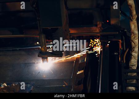 Automatic cnc laser cutting machine working with sheet metal with sparks. Metalworking industrial manufacturing factory. Stock Photo