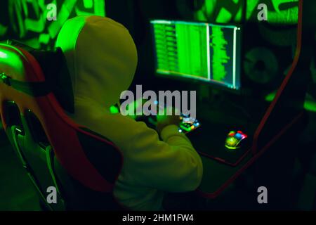 Hacker using computer malware software and hacking binary code green digital interface. Stock Photo