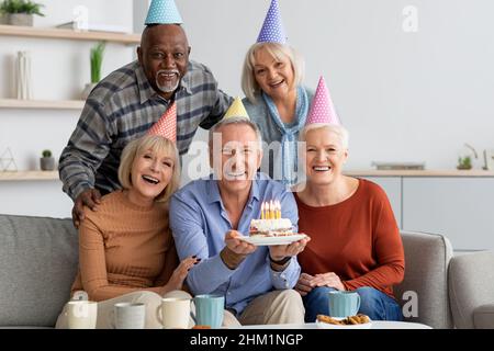 International group of elderly people having birthday party at home Stock Photo