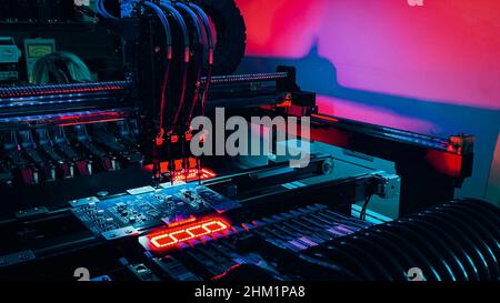 Automatic production Computer Chips by SMT Pick and Place machine. Robot Manipulators for assembling computer chips and system computer boards place electronic components on board for fixing. Stock Photo