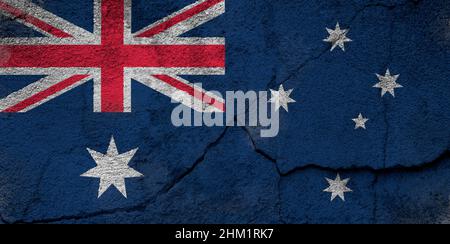 Full frame photo of a weathered flag of Australia painted on a cracked wall. Stock Photo