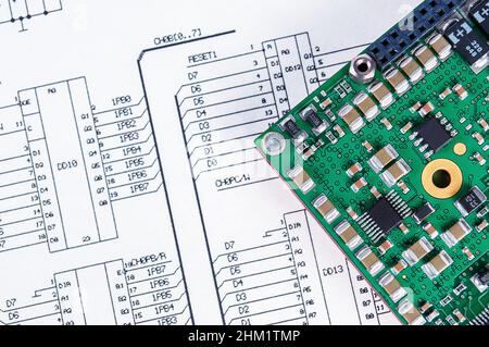 Electronic board on background of  schematic circuit diagram. Concept for development and design of electronic devices. Stock Photo