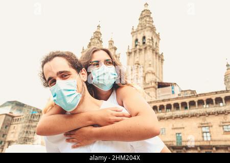 A young couple having a good time while traveling having the masks put on Stock Photo