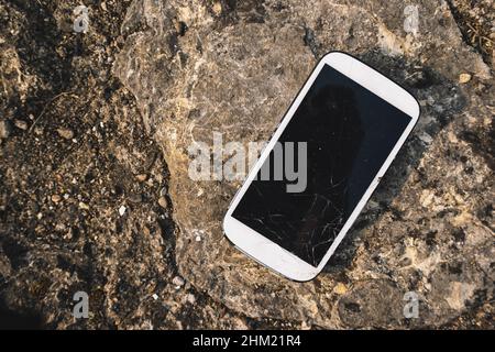 Broken Screen Smartphone on stone background Stock Photo