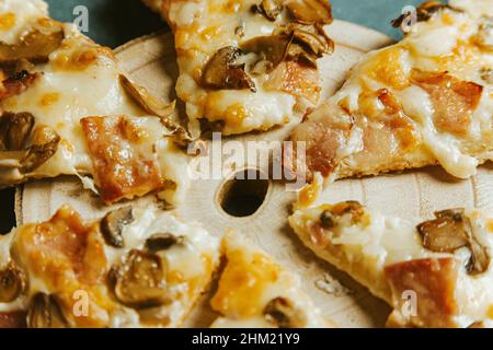 A composite shot of some pizza portions over a wooden table Stock Photo