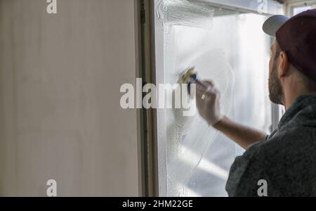 young man is using a sponge to clean a windows. professional window cleaner Stock Photo
