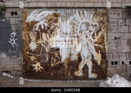 Dnepropetrovsk, Ukraine - 01.16.2022: Drawing on the old rusty garage gate in a garage cooperative. Construction of the times of the USSR. Stock Photo