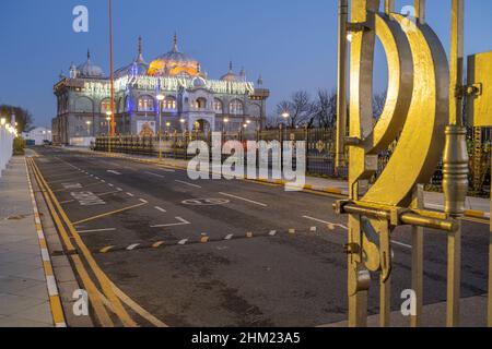 The entrance gate and the Sikh temple Siri Guru Nanak Darbar Gurdwara Gravesend Kent at night Stock Photo