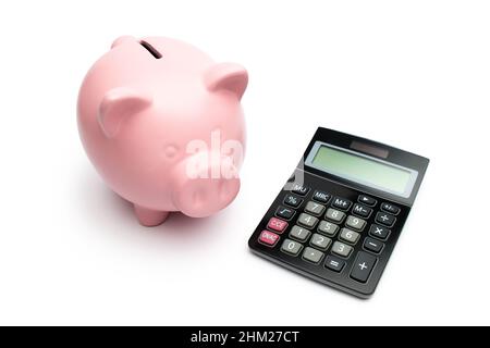 Piggybank with a black calculator on white background Stock Photo