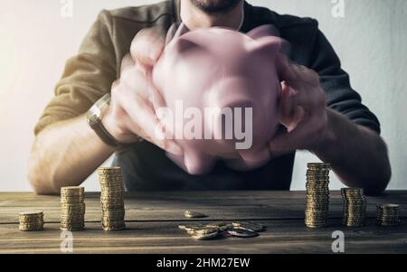 shaking piggy bank and getting coins Stock Photo