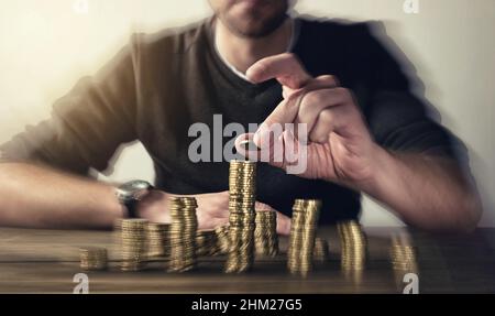 man rising coins on stacks Stock Photo