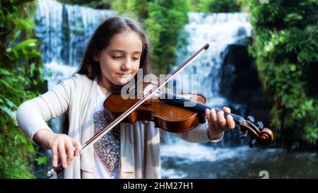 Young girl playing the viola in nature Stock Photo