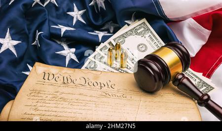 American Constitution with judge gavel and gun cartridges and dollar notes Stock Photo