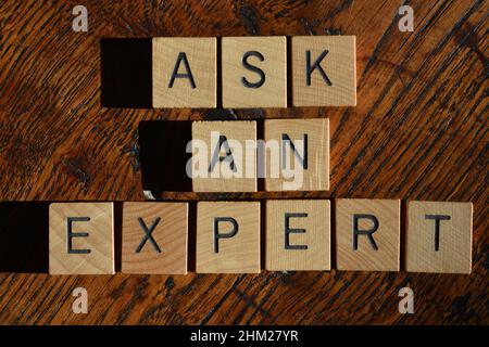 Ask An Expert, words in wooden alphabet letters on wood texture  background Stock Photo