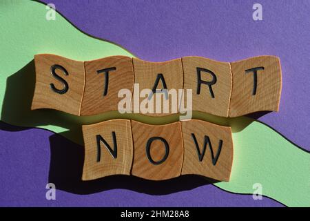 Start Now, words in wooden alphabet letters isolated on background Stock Photo