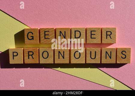 Gender Pronouns, words in wooden alphabet letters isolated on pink and yellow background Stock Photo