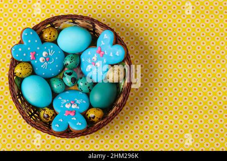 Easter gingerbreads Rabbits, Yellow and blue chicken and quail eggs in a wicker basket Stock Photo