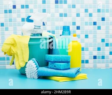 Cleaners and detergents in bucket, accessories for cleaning various surfaces and rooms blue background Stock Photo