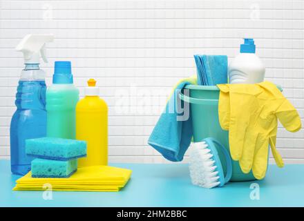 Cleaners and detergents in bucket, accessories for cleaning various surfaces and rooms blue background Stock Photo