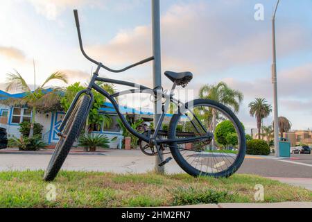 Tied bicycle on a metal posts near the road at La Jolla, California Stock Photo