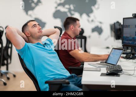 A time for relax. Young tired casual businessman relaxing at the desk in his office. Selective photo  Stock Photo