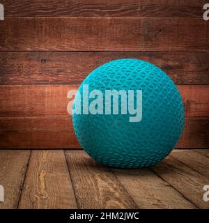 heavy rubber slam ball filled with sand on a rustic wooden background, exercise and functional fitness concept Stock Photo